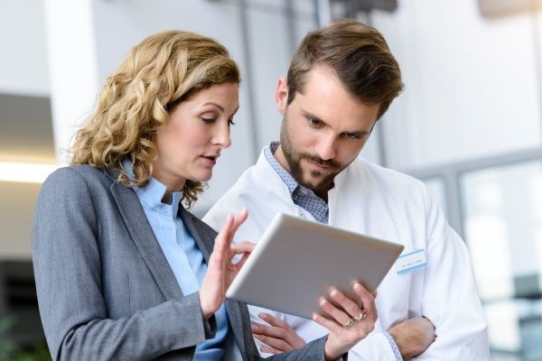 man and woman looking at tablet
